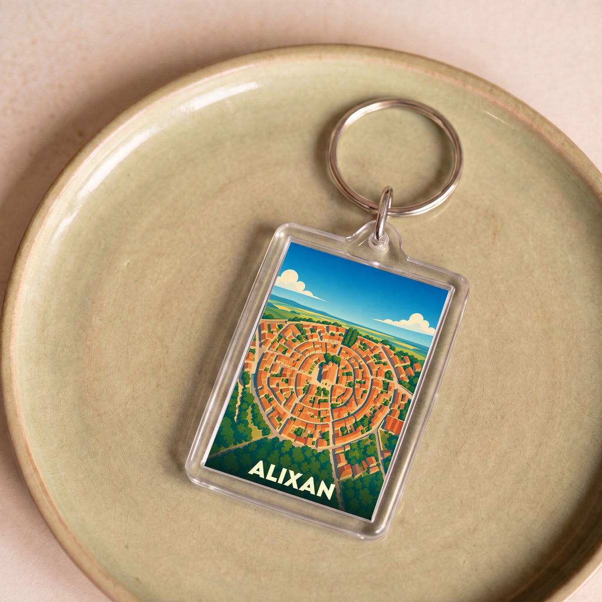 Porte-clés souvenir de la ville d'Alixan avec une illustration stylisée de son village circulaire.