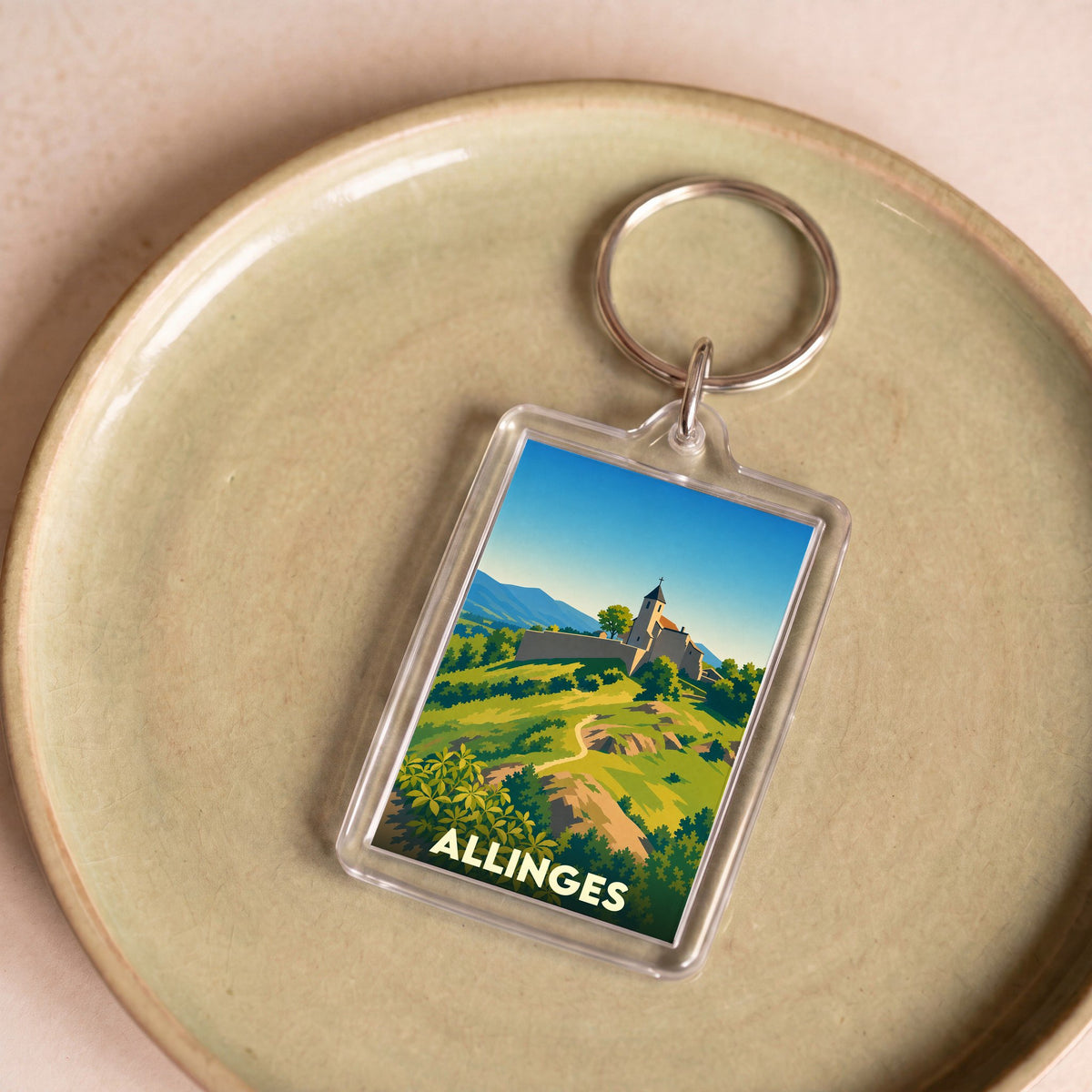 Porte-clés souvenir de la ville d'Allinges avec une illustration stylisée de ses collines et châteaux.