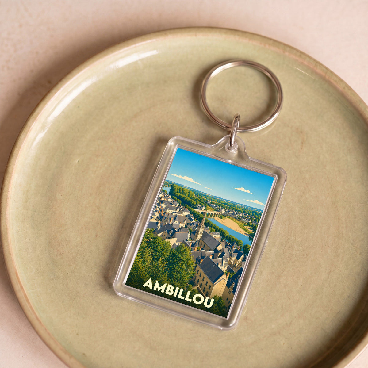 Porte-clés souvenir de la ville d'Ambillou avec une illustration panoramique stylisée.