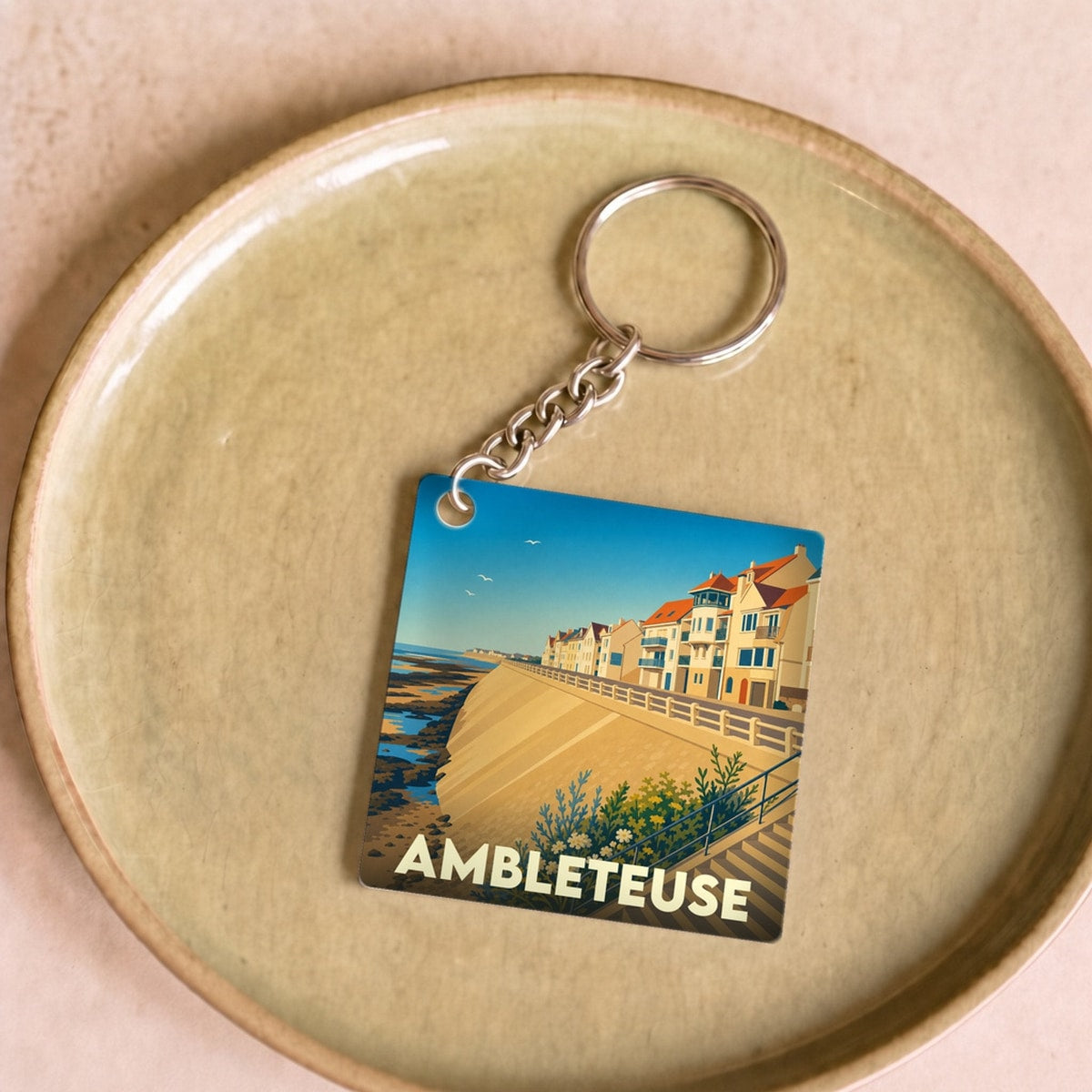 Porte-clés souvenir de la ville de Ambleteuse avec une illustration stylisée du front de mer.