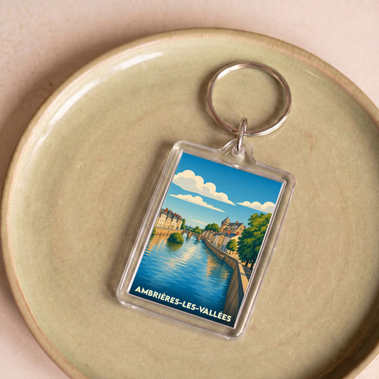 Porte-clés souvenir d'Ambrières-les-Vallées avec une illustration stylisée d'un paysage fluvial.