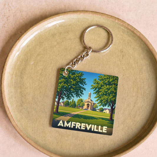 Porte-clés souvenir de la ville d'Amfreville avec une illustration stylisée de son église et d'un parc verdoyant.
