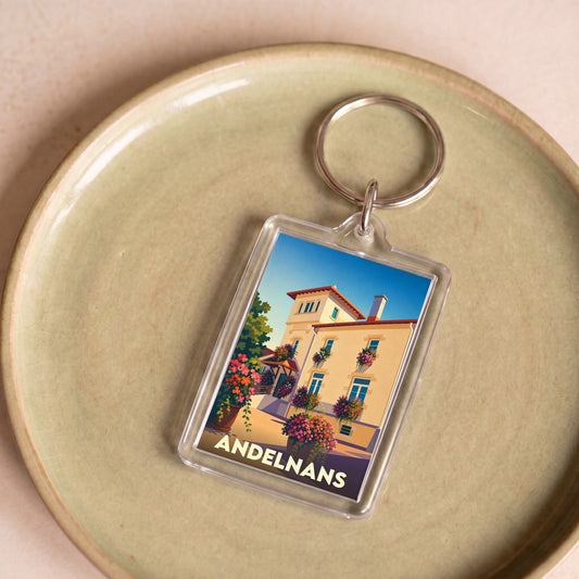 Porte-clés souvenir de la ville d'Andelnans avec une illustration stylisée d'un bâtiment fleuri.