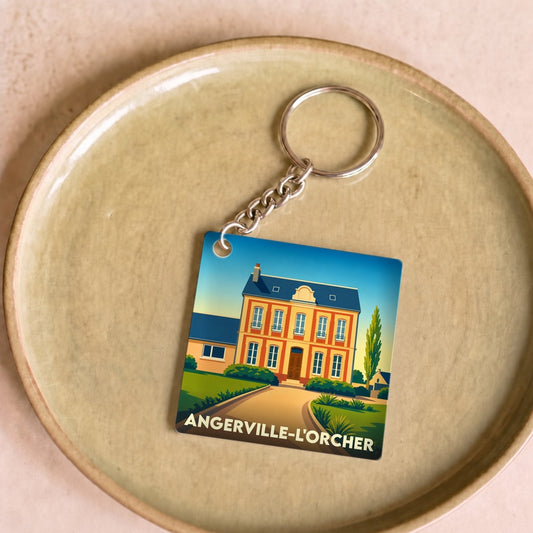 Porte-clés souvenir de la ville d'Angerville-l'Orcher avec une illustration stylisée d'une bâtisse.
