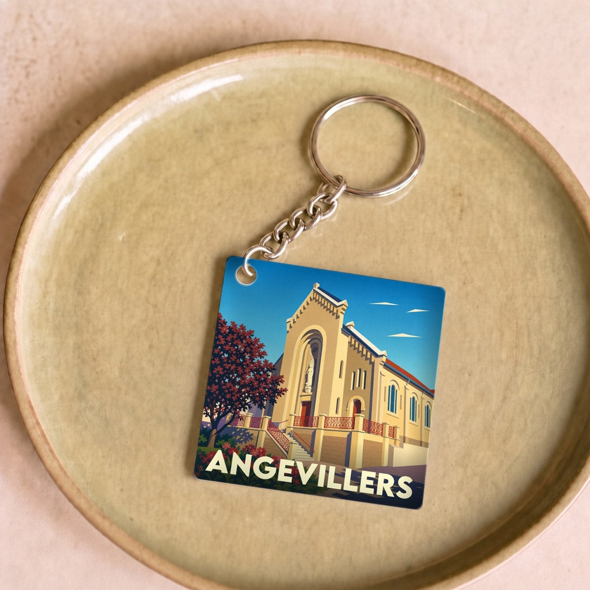 Porte-clés souvenir de la ville d'Angevillers avec une illustration stylisée de son église.