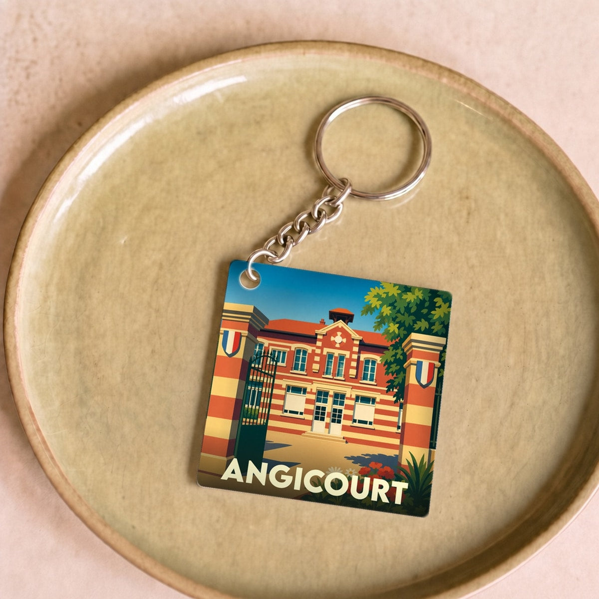Porte-clés souvenir de la ville d'Angicourt avec une illustration stylisée de sa mairie.