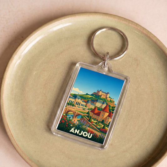 Porte-clés souvenir de la ville d'Anjou avec une illustration colorée et stylisée de son paysage urbain et de son château.