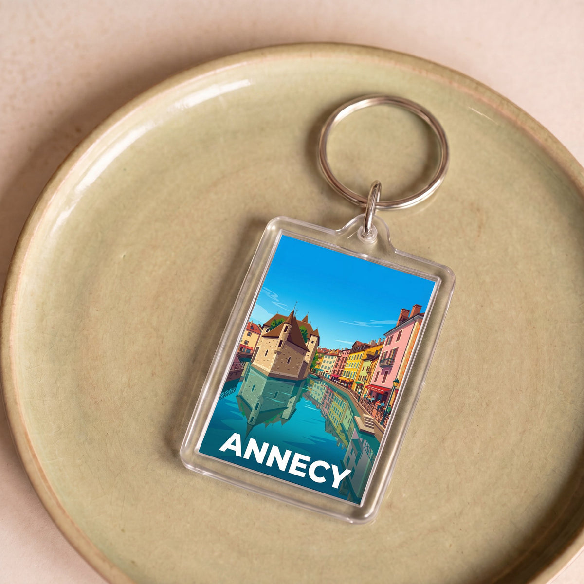 Porte-clés souvenir de la ville d'Annecy avec une illustration stylisée.