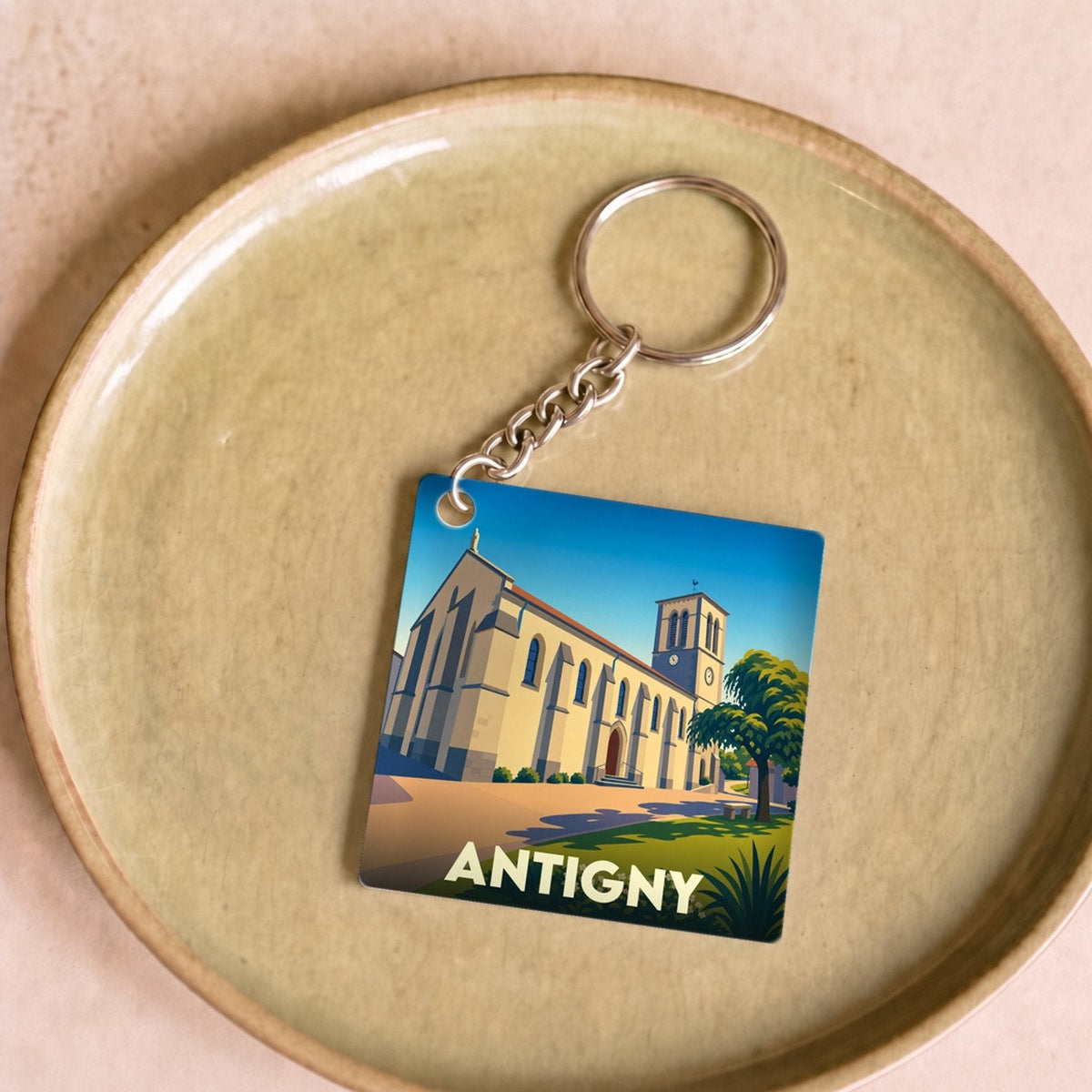 Porte-clés souvenir de la ville de Antigny avec une illustration stylisée de son église.
