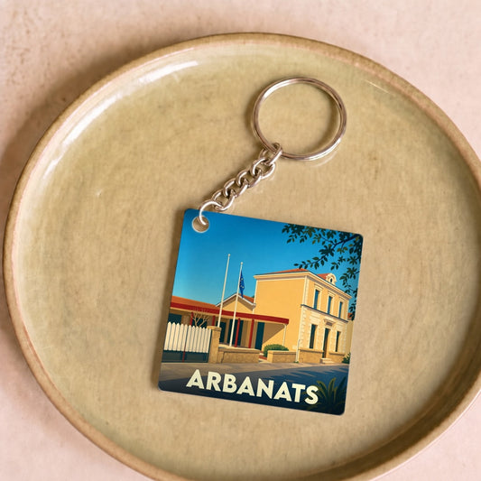 Porte-clés souvenir de la ville de Arbanats avec une illustration stylisée de sa mairie.