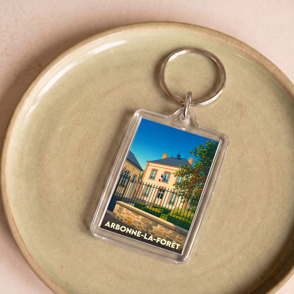 Porte-clés souvenir de la ville de Arbonne-la-Forêt avec une illustration stylisée.