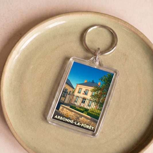 Porte-clés souvenir de la ville de Arbonne-la-Forêt avec une illustration stylisée.
