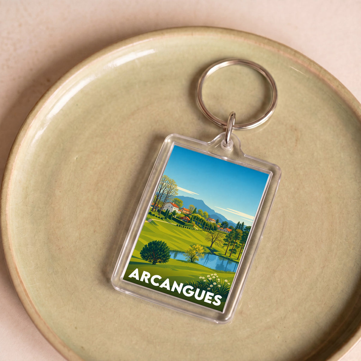 Porte-clés souvenir de la ville d'Arcangues avec une illustration stylisée de son paysage.