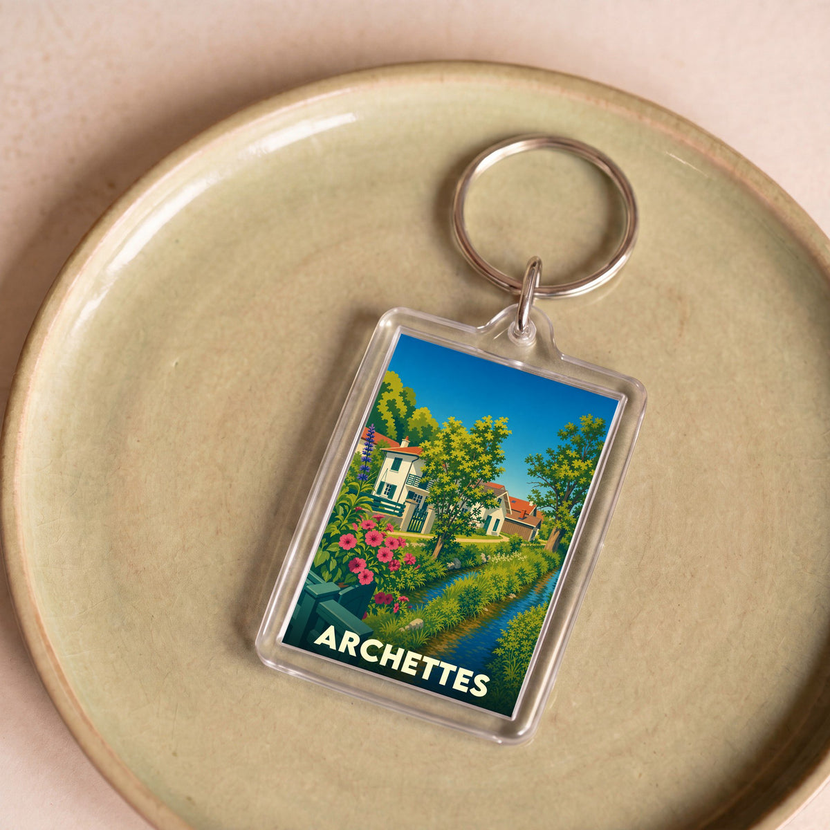 Porte-clés souvenir de la ville d'Archettes avec une illustration colorée et bucolique.