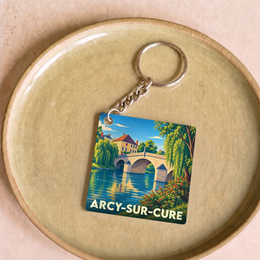 Porte-clés souvenir de la ville de Arcy-sur-Cure avec une illustration stylisée d'un pont en pierre.