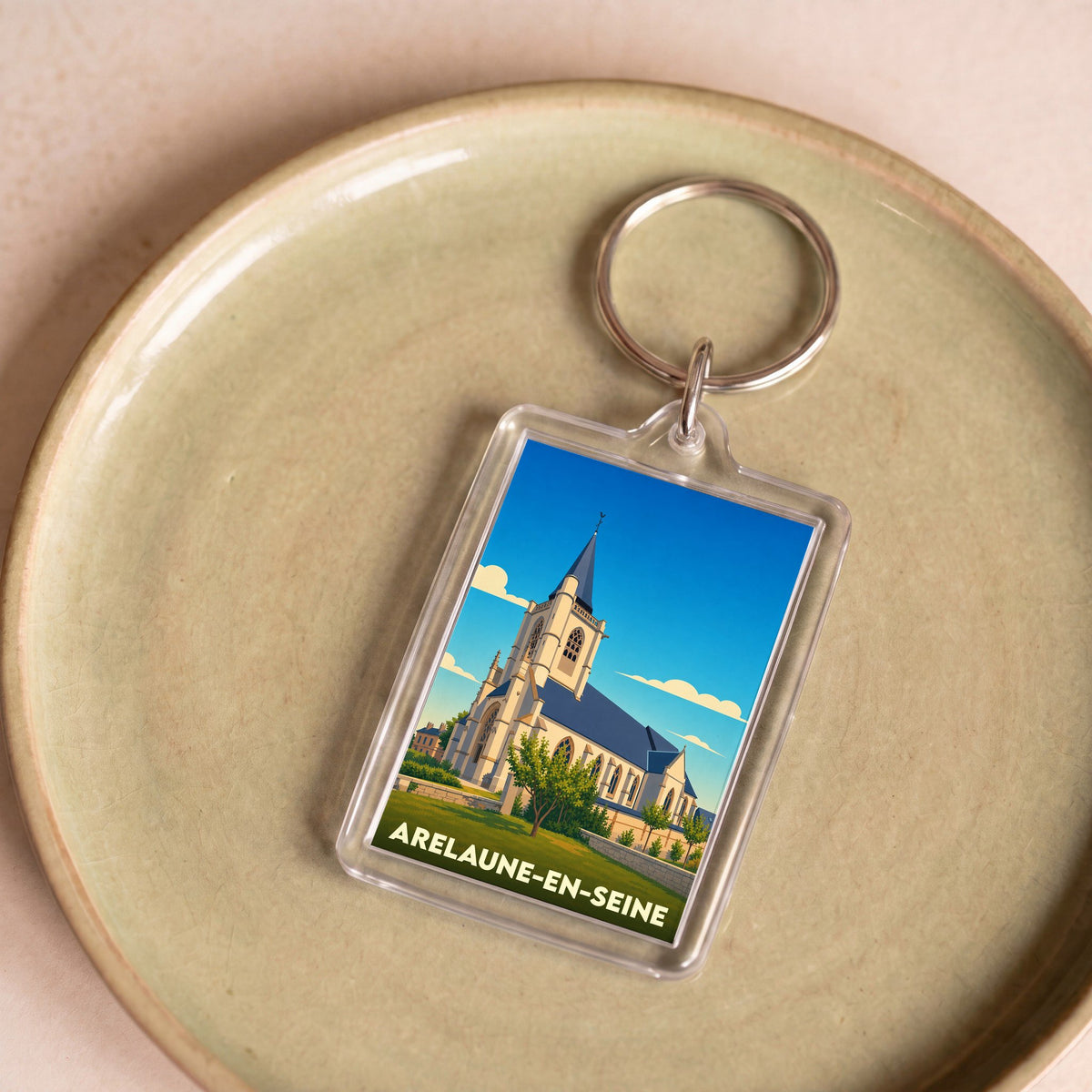 Porte-clés souvenir de la ville d'Arelaune-en-Seine avec une illustration stylisée de son église.