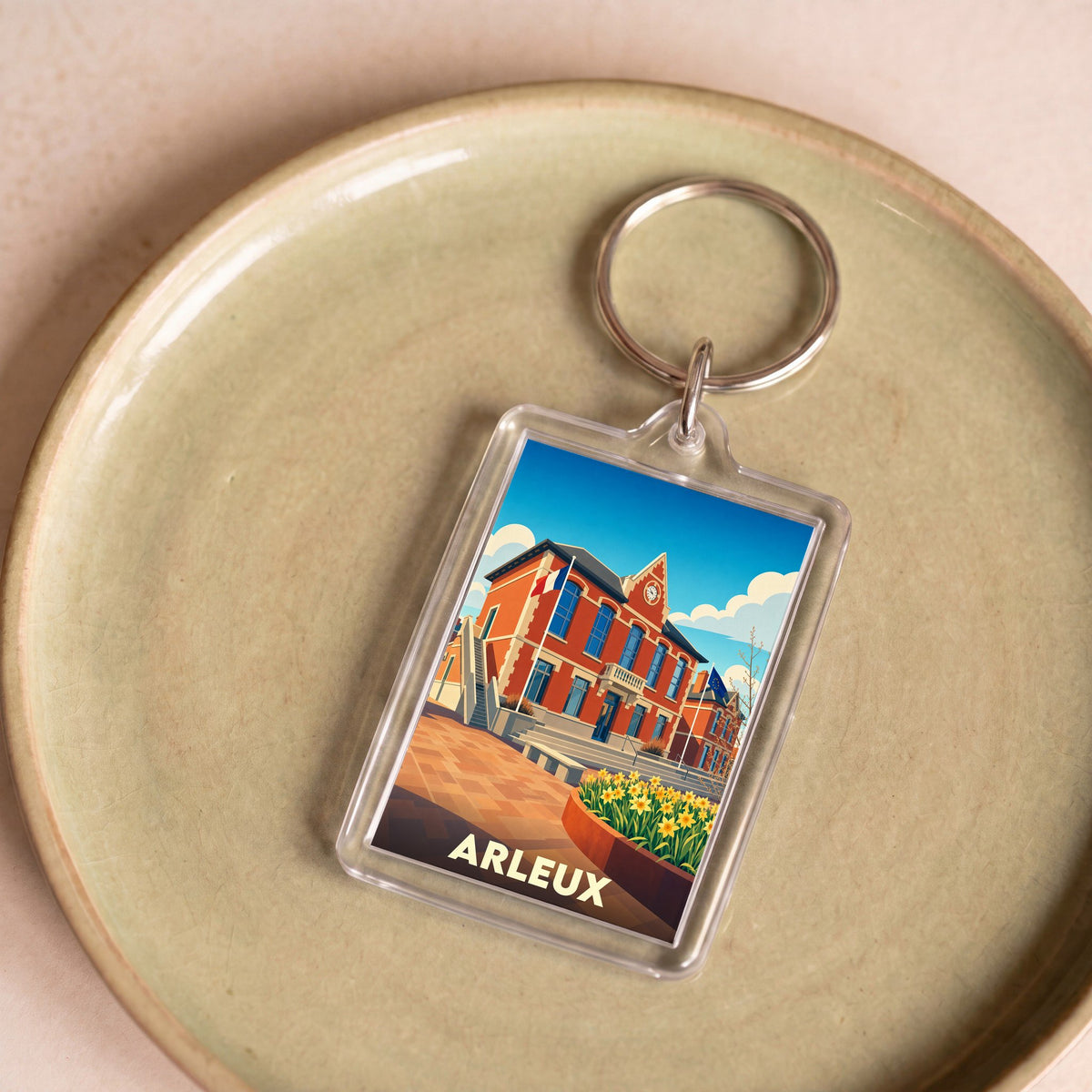Porte-clés souvenir de la ville d'Arleux avec une illustration colorée et stylisée de son hôtel de ville.