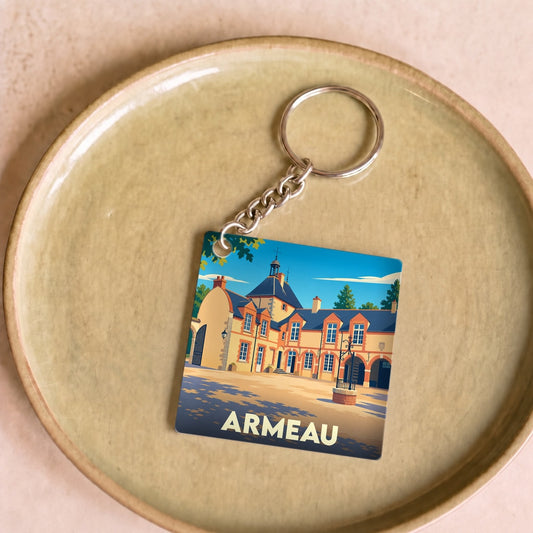 Porte-clés souvenir de la ville d'Armeau avec une illustration stylisée de son architecture.