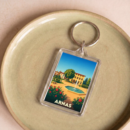 Porte-clés souvenir de la ville d'Arnas avec une illustration stylisée d'un parc ensoleillé.
