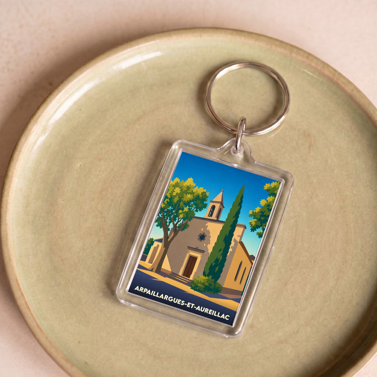 Porte-clés souvenir de la ville de Arpaillargues-et-Aureillac avec une illustration stylisée de son église.