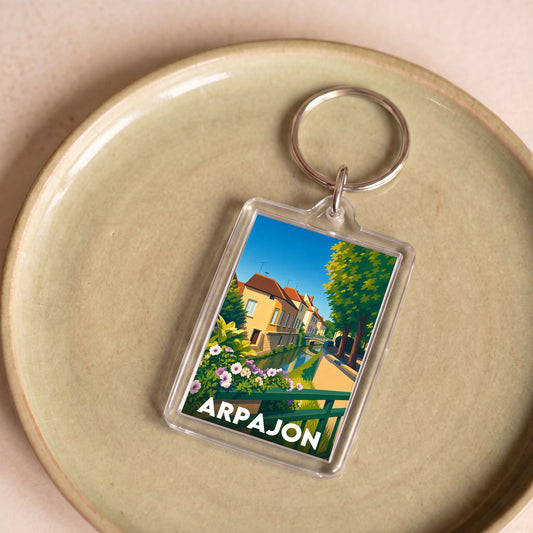 Porte-clés souvenir de la ville d'Arpajon avec une illustration stylisée.