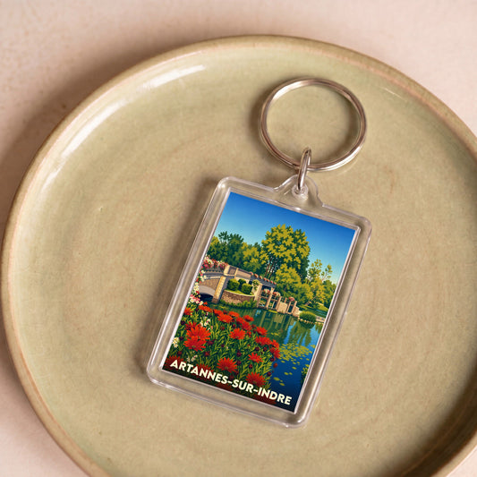 Porte-clés souvenir de la ville d'Artannes-sur-Indre avec une illustration stylisée d'un pont fleuri.