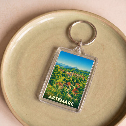Porte-clés souvenir de la ville d'Artemare avec une illustration paysagère stylisée.