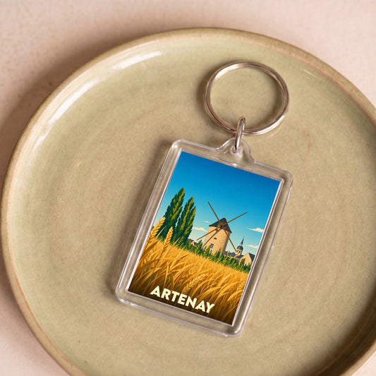 Porte-clés souvenir de la ville d'Artenay avec une illustration stylisée d'un moulin et d'un champ de blé.