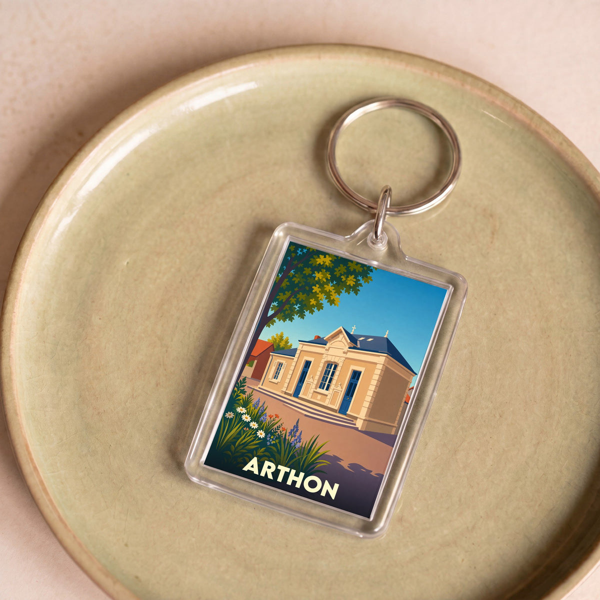 Porte-clés souvenir de la ville d'Arthon avec une illustration stylisée de sa mairie.