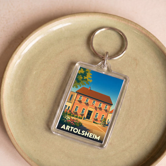 Porte-clés souvenir de la ville de Artolsheim avec une illustration stylisée d'une maison fleurie.