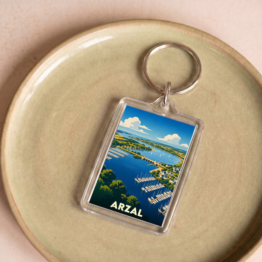Porte-clés souvenir de la ville d'Arzal avec une illustration stylisée de son port et de son barrage.