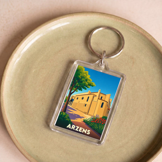 Porte-clés souvenir de la ville d'Arzens avec une illustration stylisée de son église.