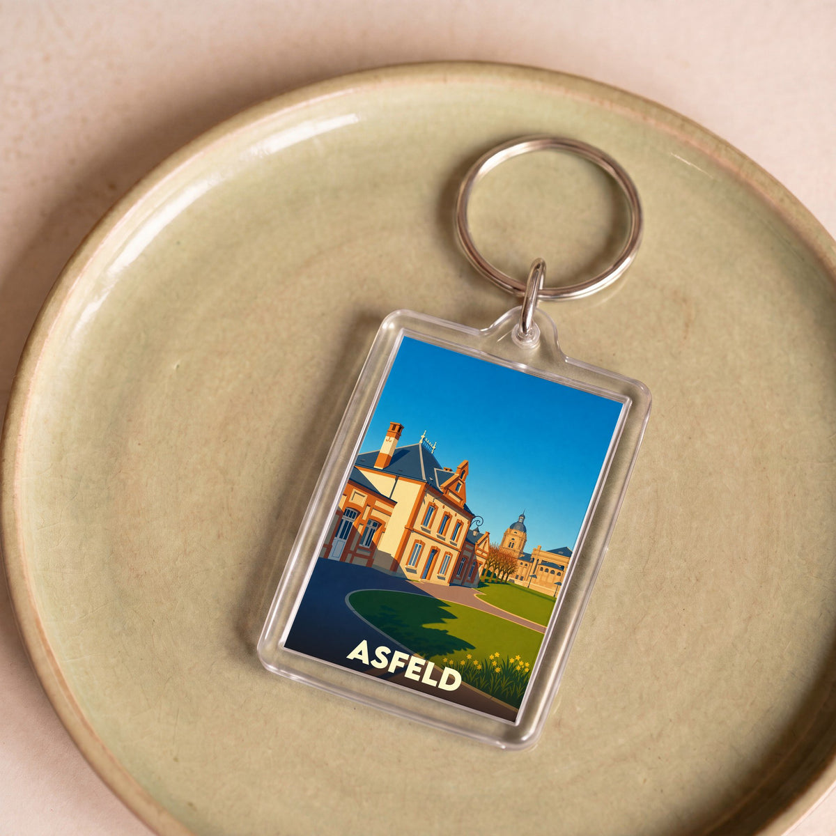 Porte-clés souvenir de la ville d'Asfeld avec une illustration stylisée.