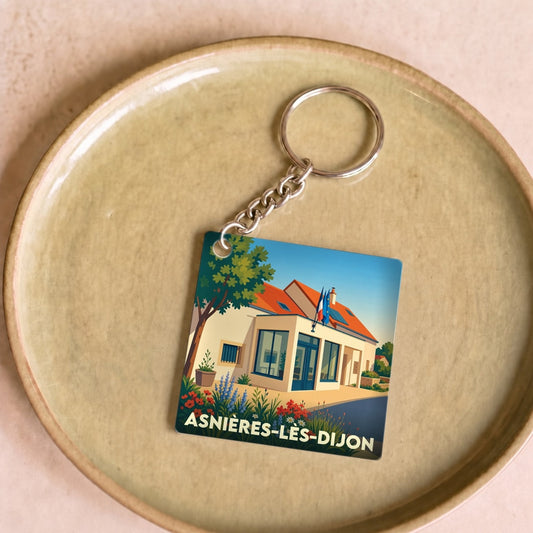 Porte-clés souvenir de la ville d'Asnières-lès-Dijon avec une illustration stylisée.