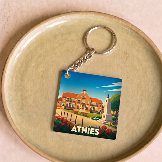Porte-clés souvenir de la ville d'Athies avec une illustration stylisée d'une place fleurie.