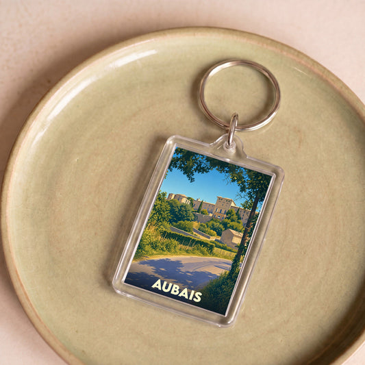 Porte-clés souvenir de la ville d'Aubais avec une illustration stylisée de son paysage.