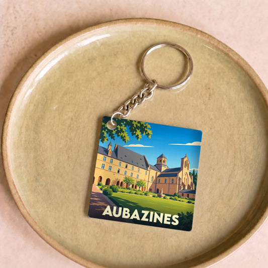 Porte-clés souvenir de la ville d'Aubazines avec une illustration stylisée de son abbaye.