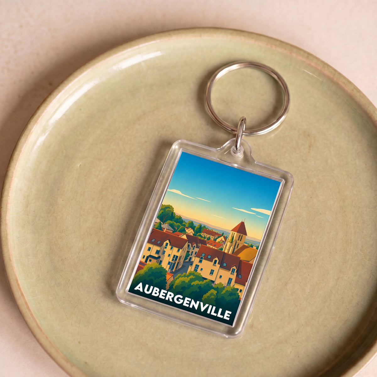 Porte-clés souvenir de la ville d'Aubergenville avec une illustration colorée et stylisée.