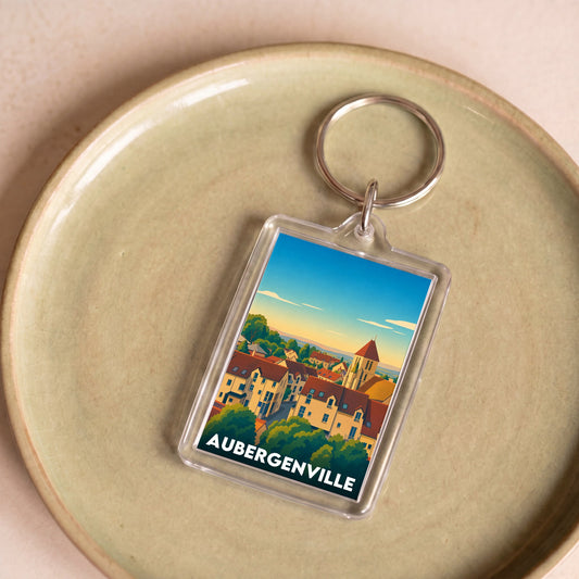 Porte-clés souvenir de la ville d'Aubergenville avec une illustration colorée et stylisée.