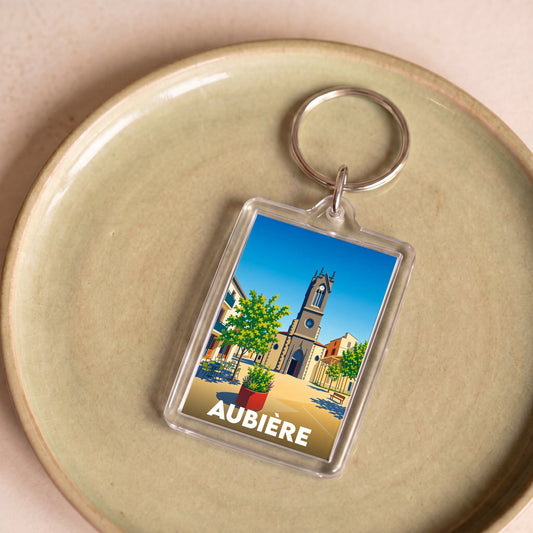 Porte-clés souvenir de la ville d'Aubière avec une illustration stylisée.