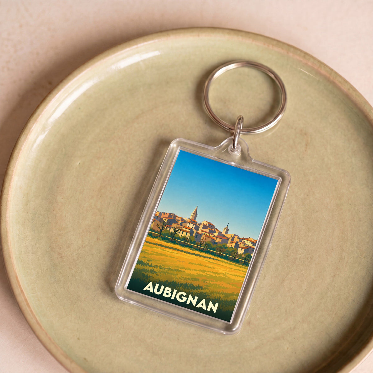 Porte-clés souvenir de la ville de Aubignan avec une illustration stylisée.