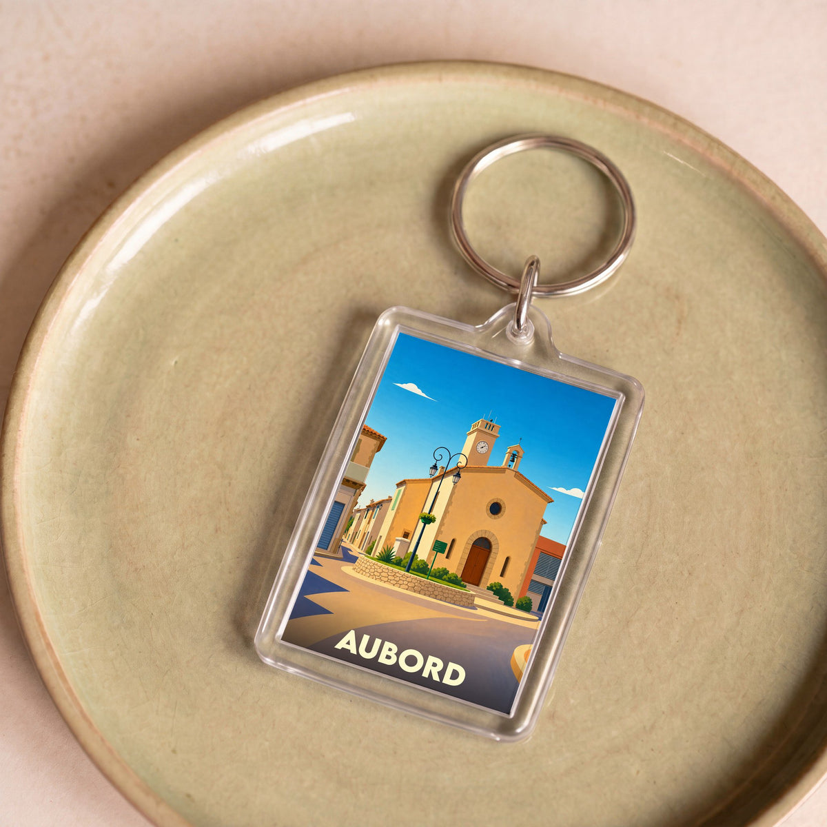 Porte-clés souvenir de la ville de Aubord avec une illustration stylisée de son église.