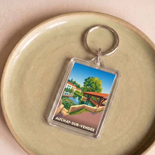 Porte-clés souvenir de la ville de Auchay-sur-Vendée avec une illustration stylisée d'un paysage local.