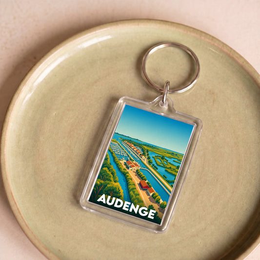 Porte-clés souvenir de la ville d'Audenge avec une illustration stylisée du port.