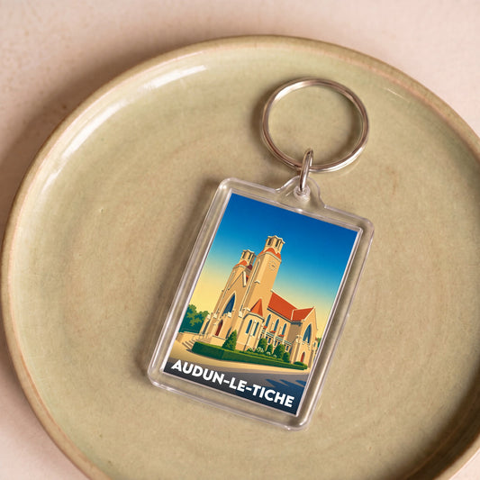 Porte-clés souvenir de la ville de Audun-le-Tiche avec une illustration stylisée de son église.