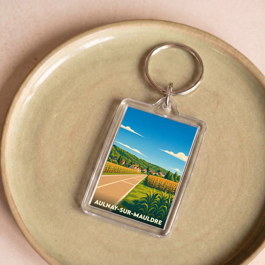 Porte-clés souvenir de la ville d'Aulnay-sur-Mauldre avec une illustration stylisée de son paysage rural.