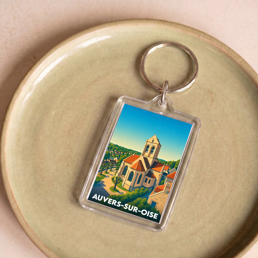 Porte-clés souvenir de la ville d'Auvers-sur-Oise avec une illustration stylisée de son église emblématique.