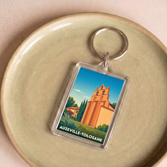 Porte-clés souvenir de la ville de Auzeville-Tolosane avec une illustration stylisée de son église.