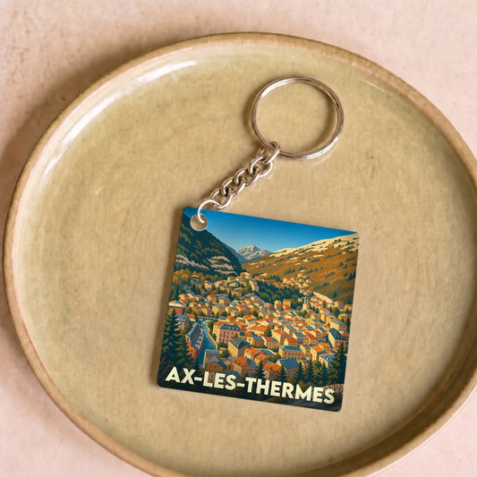Porte-clés souvenir de la ville de Ax-les-Thermes avec une illustration stylisée.