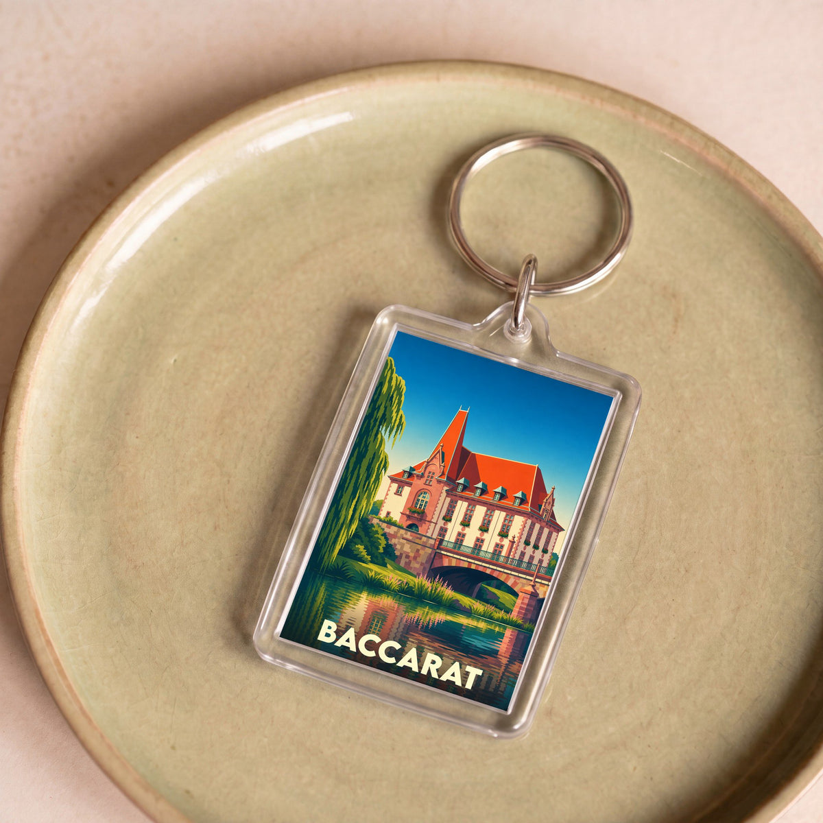 Porte-clés souvenir de la ville de Baccarat avec une illustration stylisée.